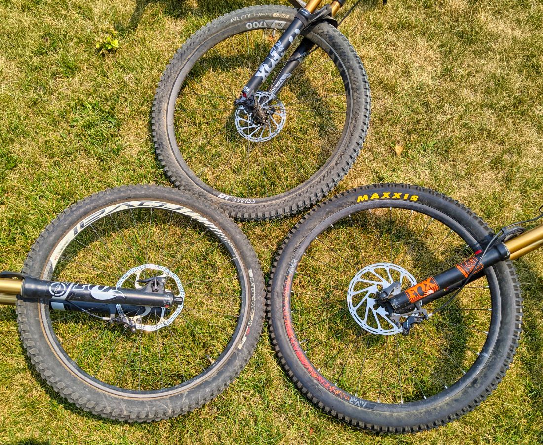 26, 27.5, and 29 inch mountain bike wheels in comparison on a lawn