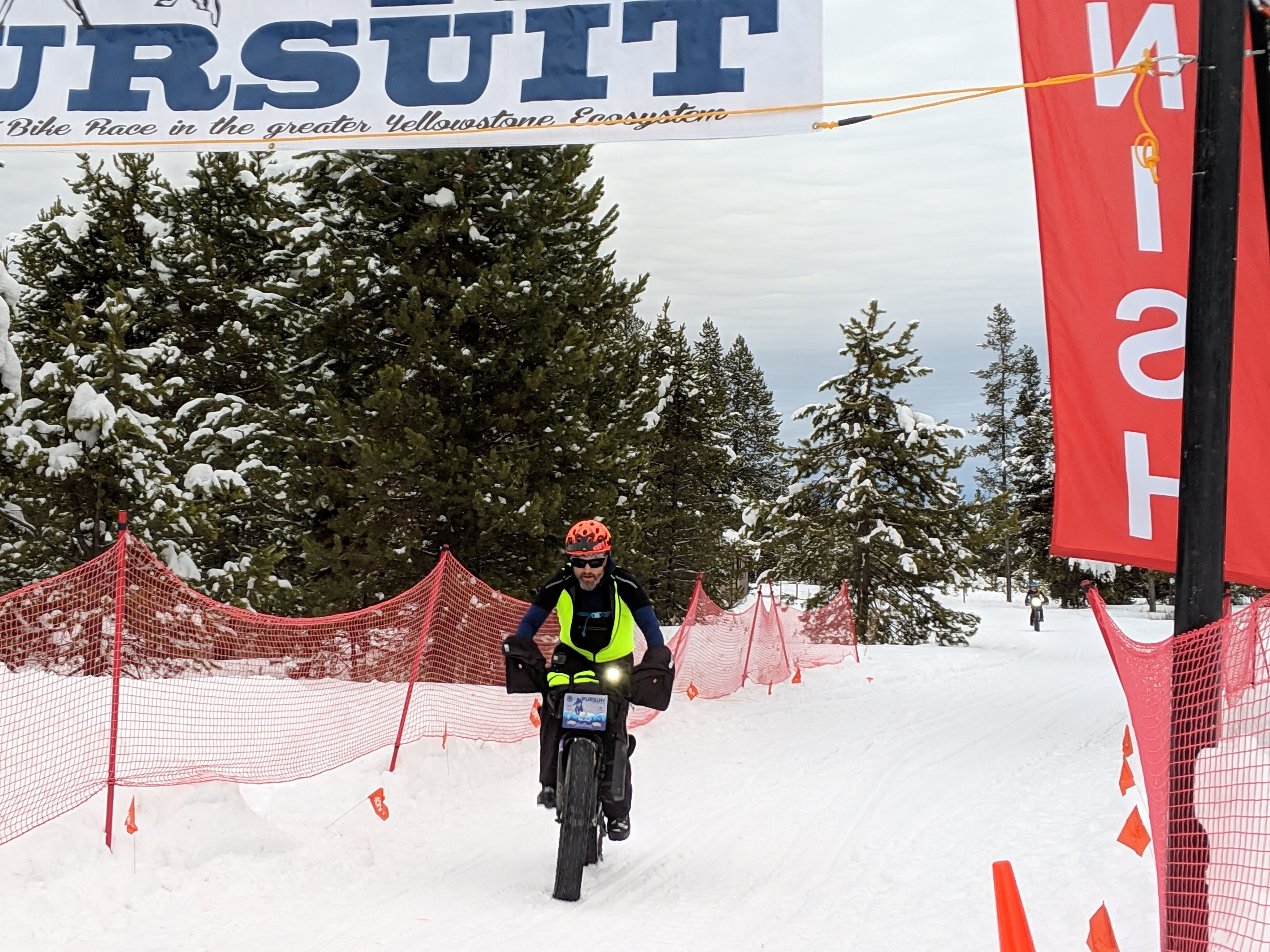 Mountain bike racer crossing the finish line on a fat bike in the snow