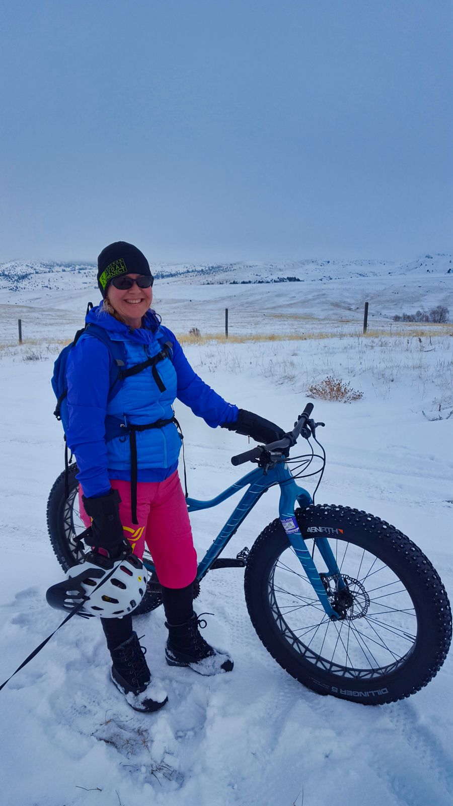 Mountain biker standing next to her fatbike in the snow
