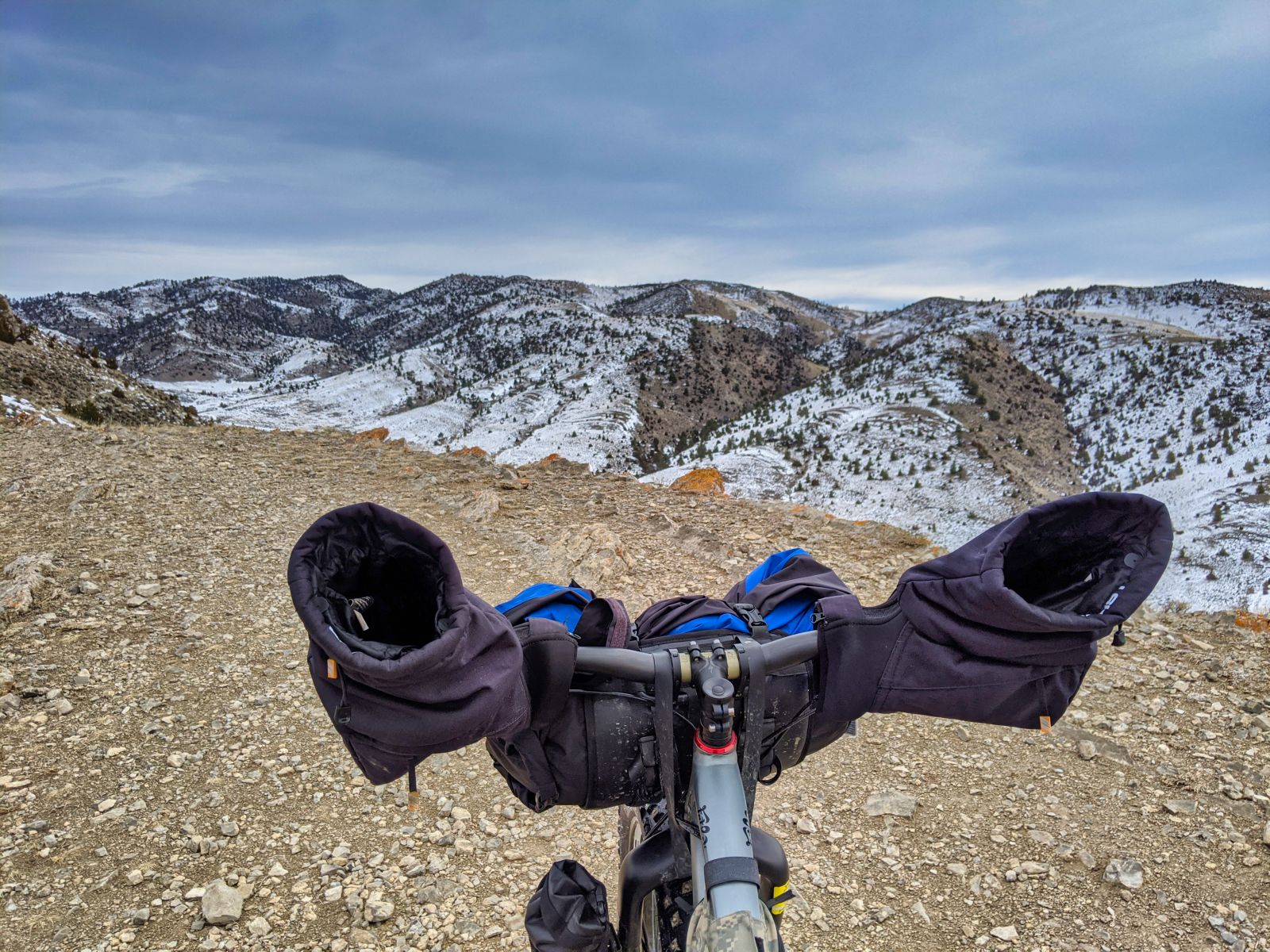 Mountain bike hand covers, called pogies on a bike in the mountains during winter